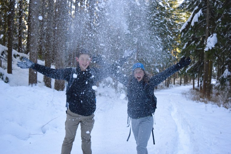 Two people throw snow into the air. Photo by Alex Oishi. 