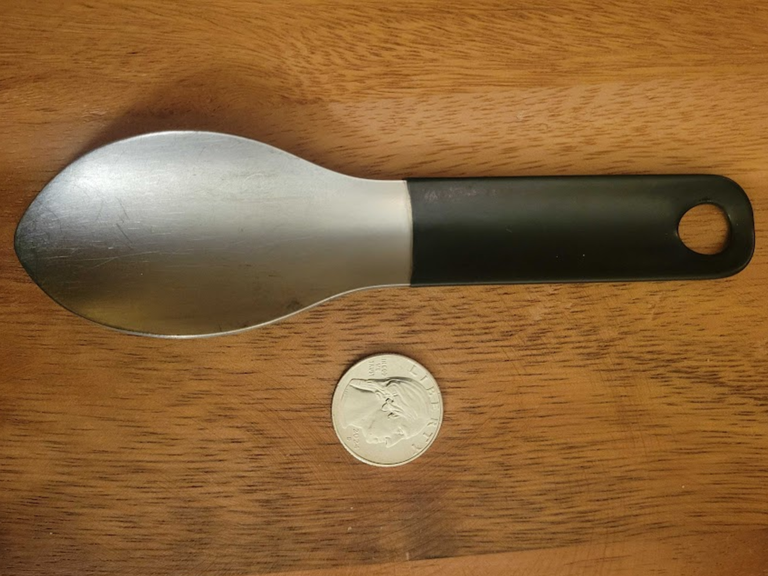 A trowel and a quarter on wood grain.