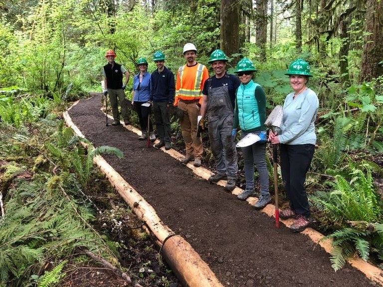 Volunteers standing on a recently repaired section of graveled trail. Photo by Mike Bellis.