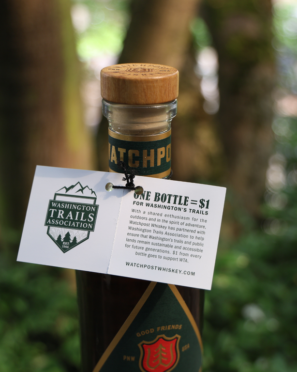 A tag featuring WTA's logo on a bottle of whiskey with a green and red label. Photo by Victoria Obermeyer.