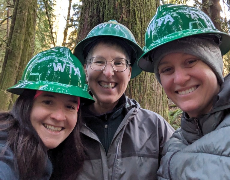 WTA staff at Flowing Lake Three green hats smile for a photo at Flowing Lake Couty Park