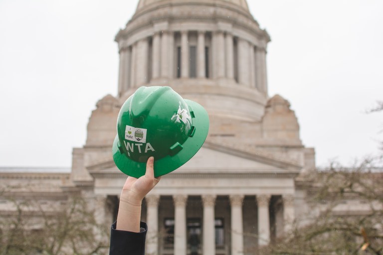 A WTA hard hat raised in front of the Capitol building