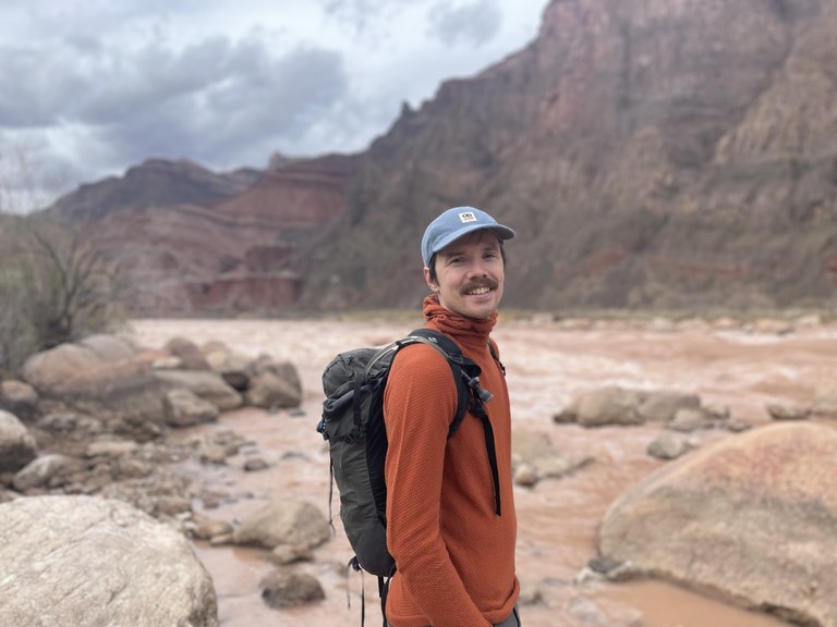 WTA's statewide trails program manager is looking forward to the 2023 season. Photo by Austin Easter A hiker stands next to a muddy river.