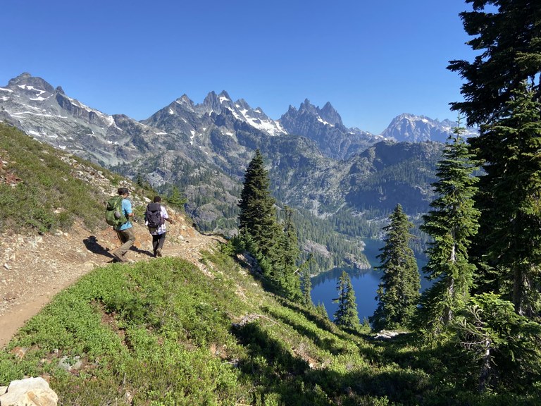 LTF crewmembers hike down a scenic mountain trail.