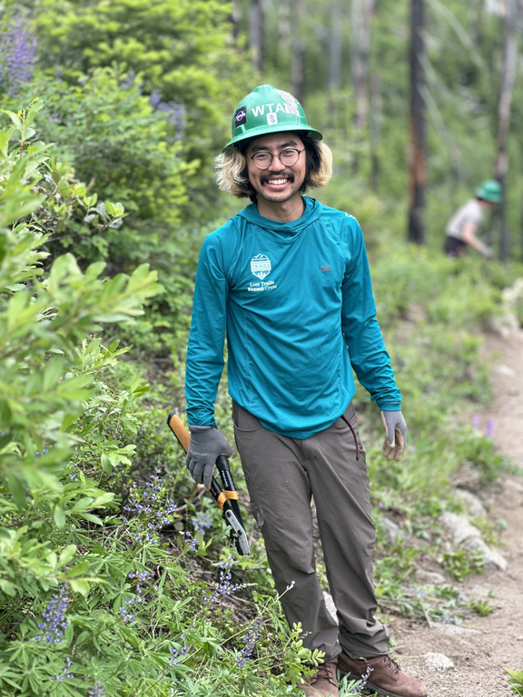 Zenwa is well aware of the challenges previous years have presented — and how to wield that experience into 2023. Photo by Zenwa Shimabukuro A crewmember stands amongst verdant foliage.