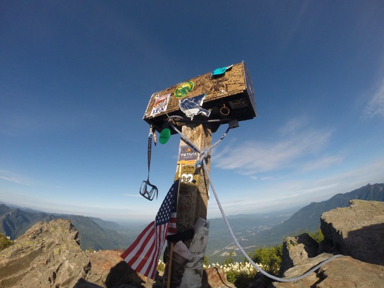 A hiker at the Mailbox Peak summit mailbox