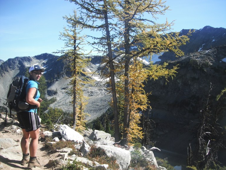 a hiker in a blue shirt turns over her shoulder towards the photographer 