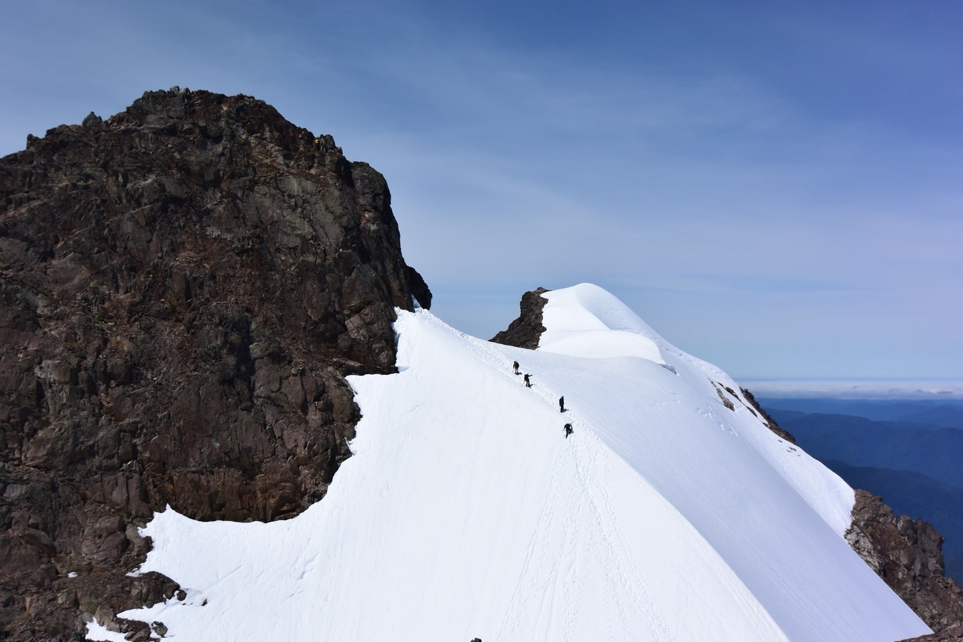 Descend from the base of summit rock pitch to the saddle between true and false summit