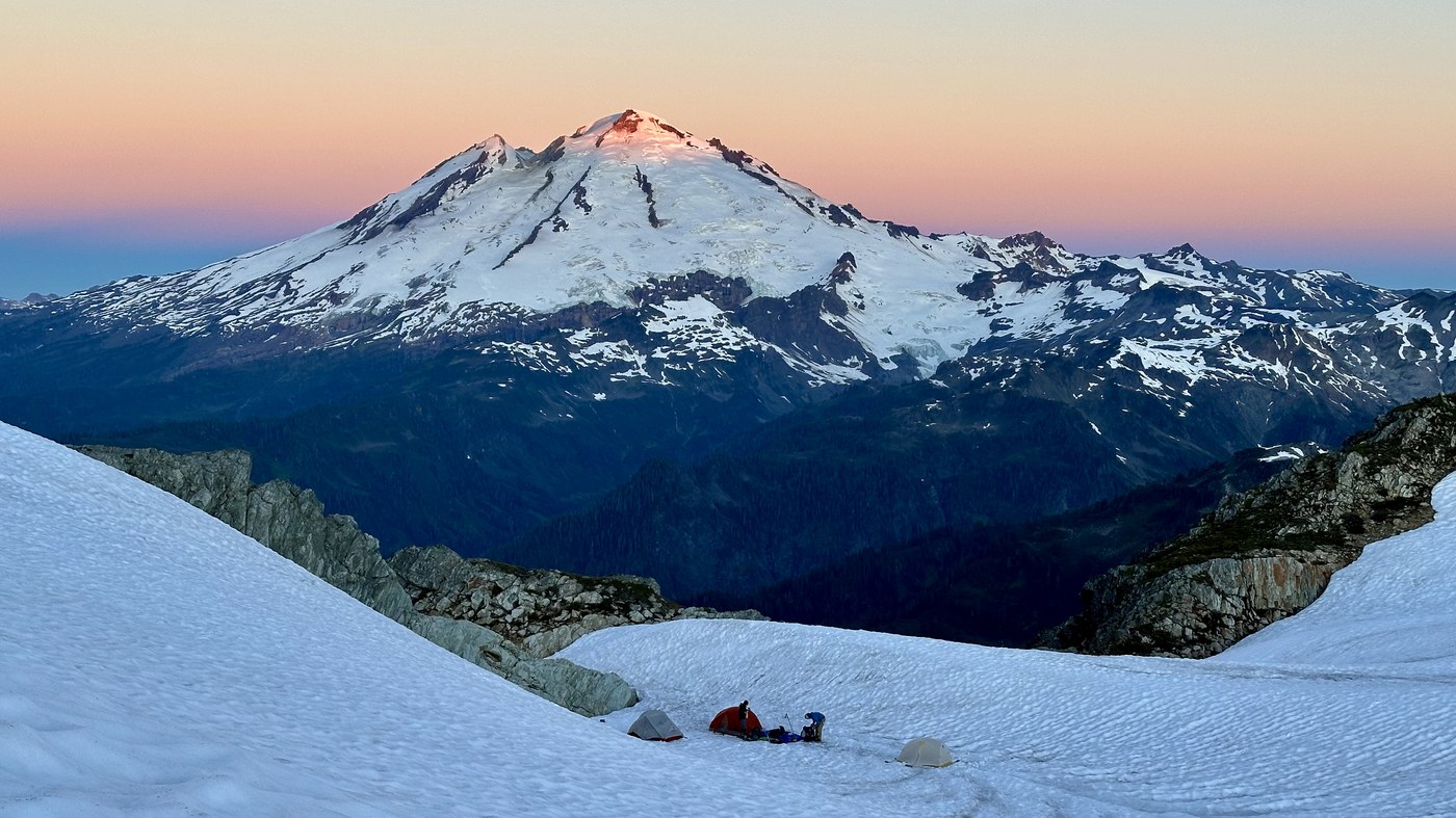 Sun hitting Mt Baker with tents below