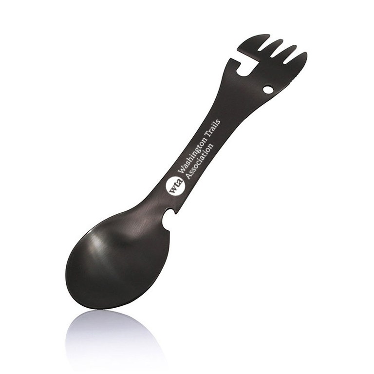 A black metal utensil with a fork on one end and a spoon on the other. There are several spaces cut out to create a bottle and can opener. The Washington Trails Association logo is printed in white on the handle.